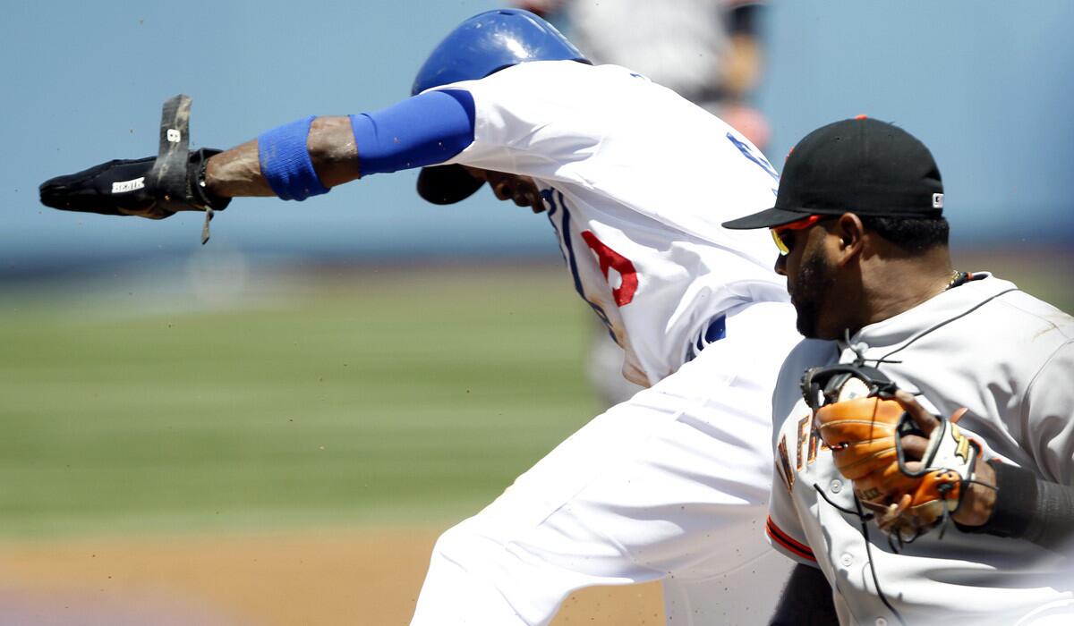 Dodgers second baseman Dee Gordon steals third base before Giants third baseman Pablo Sandoval can make a tag in the first inning Saturday afternoon.
