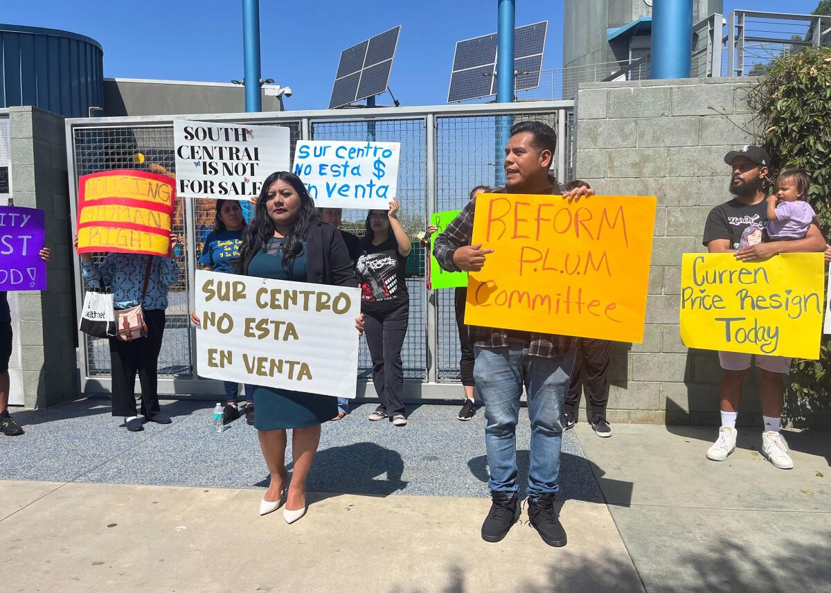 Protesters hold signs in English and Spanish.
