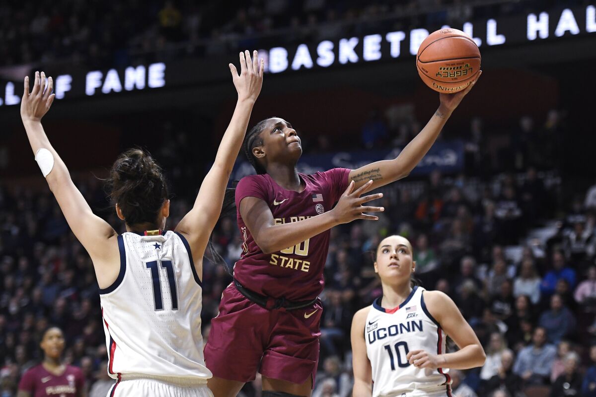 FILE - Florida State's Ta'niya Latson goes up for a basket as Connecticut's Lou Lopez-Senechal (11) defends during the second half of an NCAA college basketball game, Sunday, Dec. 18, 2022, in Uncasville, Conn. Latson, the ACC Rookie of the Year, will miss the NCAA Tournament with an undisclosed injury. She averaged 21.3 points and 4.5 rebounds this season. (AP Photo/Jessica Hill, File)