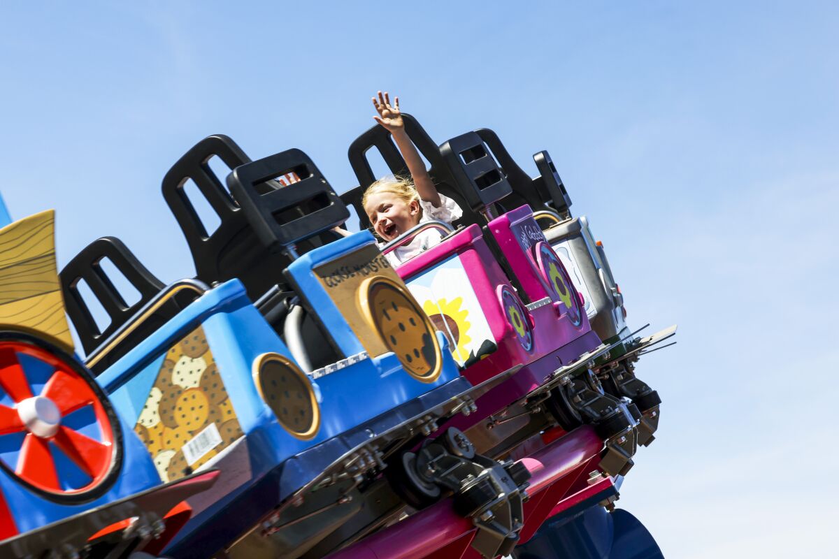 A girl smiles on a roller coaster at Sesame Place