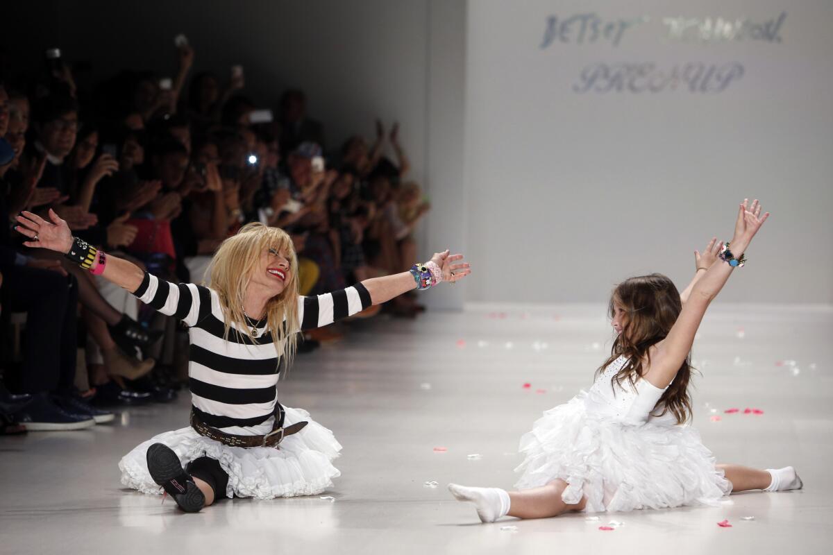 Betsey Johnson, left, does a split after cartwheeling with her granddaughter, Layla Margulies, 8, during the finale of her Spring 2015 fashion show in September 2014.