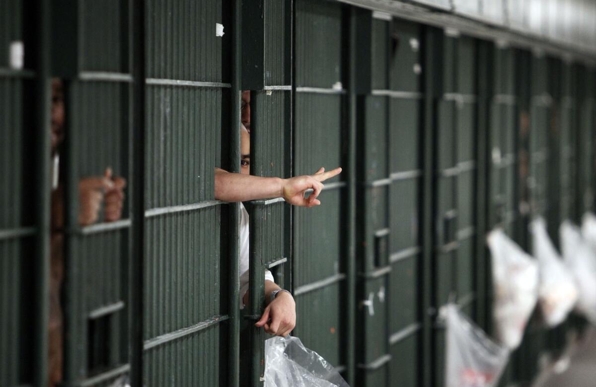 An inmates flashes a hand signal at the Men's Central Jail in downtown Los Angeles. Two Los Angeles County sheriff's deputies were indicted on charges of assaulting an inmate and submitting false reports.