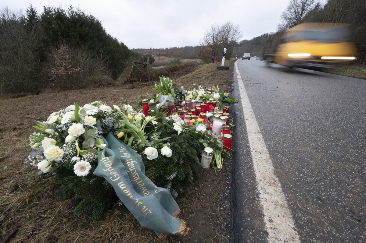 Flowers and candles stand in Ulmet, near Kusel, Germany, Friday, Feb. 4, 2022 at the scene where two police officers were shot during a traffic stop . German investigators have found nearly 400 cases of online hate speech related to last week's killing of two police officers, a shooting apparently meant to cover up the fact the suspects had been poaching wild animals, authorities said Monday. The 399 posts included 102 that were “criminally relevant,” and 15 suspects already have been tracked down, officials in the western state of Rhineland-Palatinate said. (Sebastian Gollnow/dpa via AP)