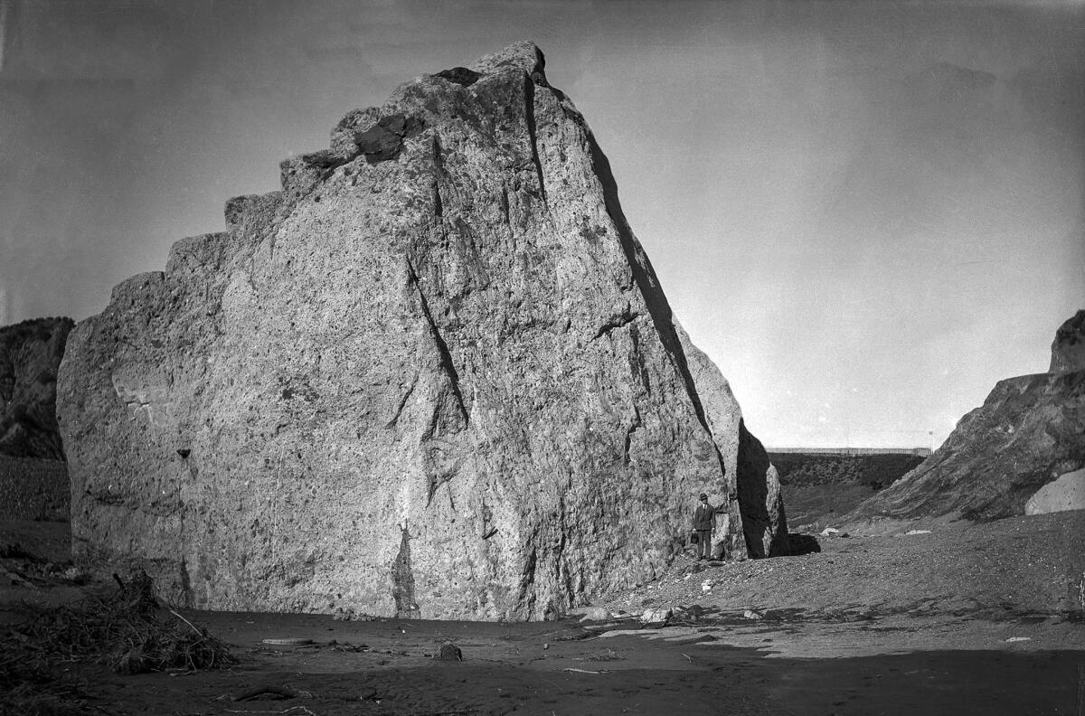 March 15, 1928: A giant piece of concrete from the St. Francis Dam that was carried about three-quarters of a mile downstream dwarfs a man standing at lower right.