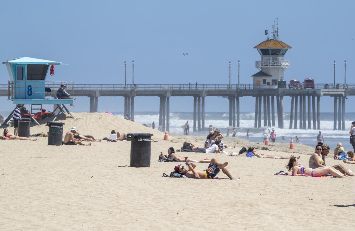 People relax on the sand in Huntington Beach on Monday, despite the state's active-use-only allowance. The city of Huntington Beach is still pursuing a lawsuit against the state to reopen the beach to all forms of activities.
