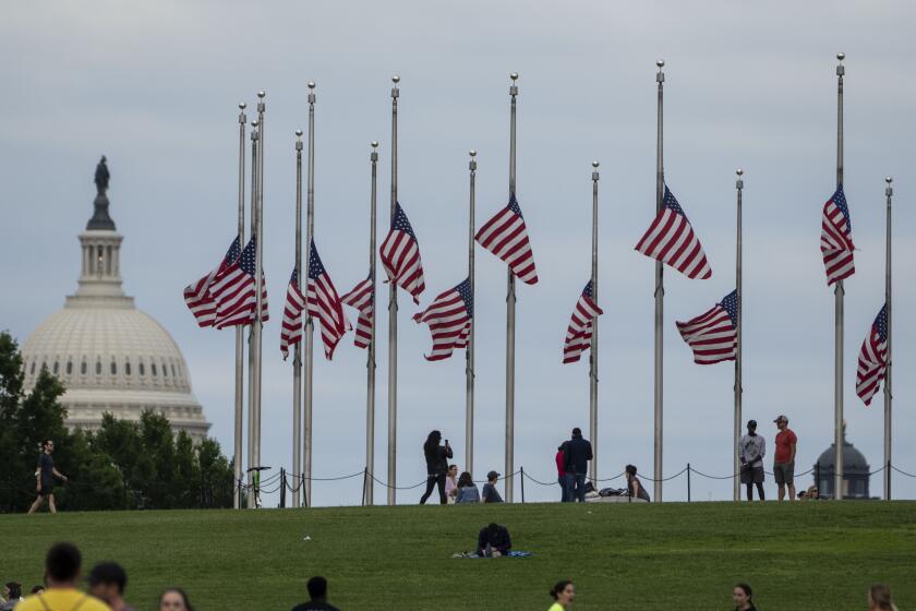 WASHINGTON, DC - MAY 25: American flags are seen at half-staff surrounding the Washington Monument as people enjoy the weather on the National Mall on Wednesday, May 25, 2022 in Washington, DC. President Joe Biden ordered that the flags at the White House, federal buildings and military posts be flown at half-staff for the victims of a deadly shooting at an elementary school in Uvalde, Texas (Kent Nishimura / Los Angeles Times)