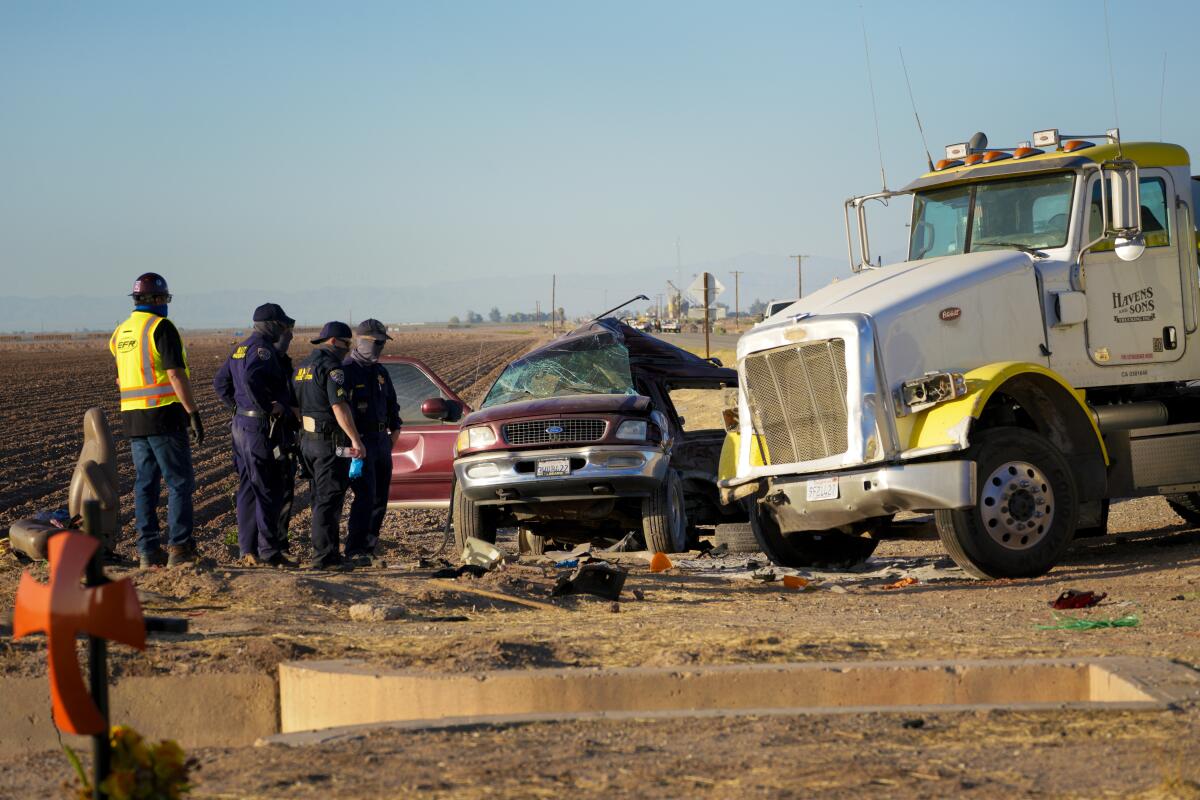Investigators look over the scene of a deadly crash