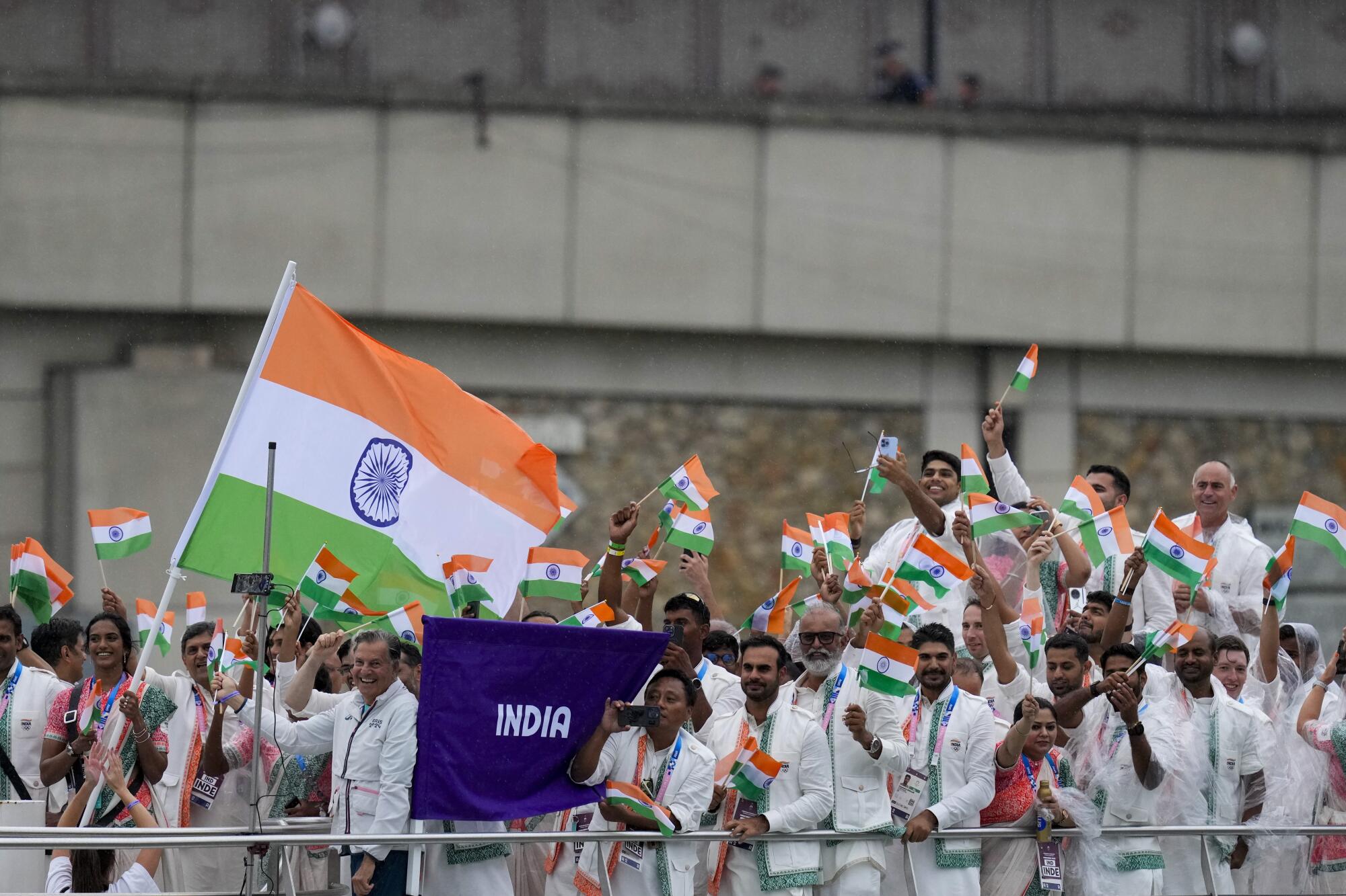 Team India waving flags large and small on a boat.