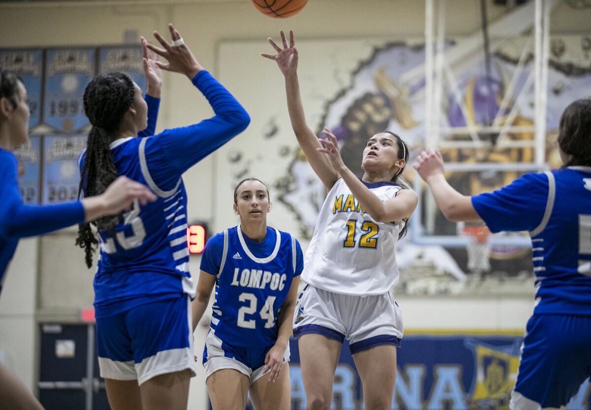 Marina's Emely Gomez takes a shot against Lompoc's Cierra Bailey, left, on Tuesday.