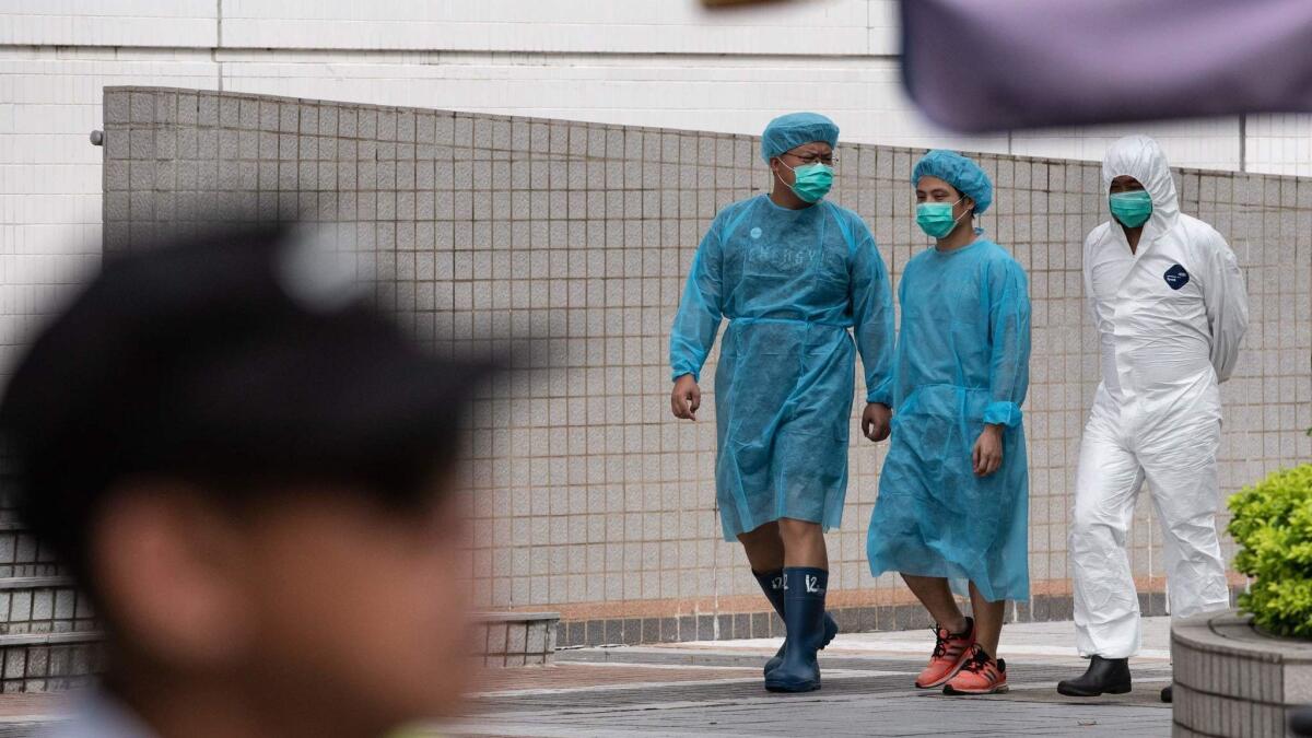 Staff members in protective gowns walk inside the Sheung Shui slaughterhouse in Hong Kong. Authorities have culled thousands of pigs from mainland China after African swine fever was detected in an animal at a slaughterhouse close to the border with China.