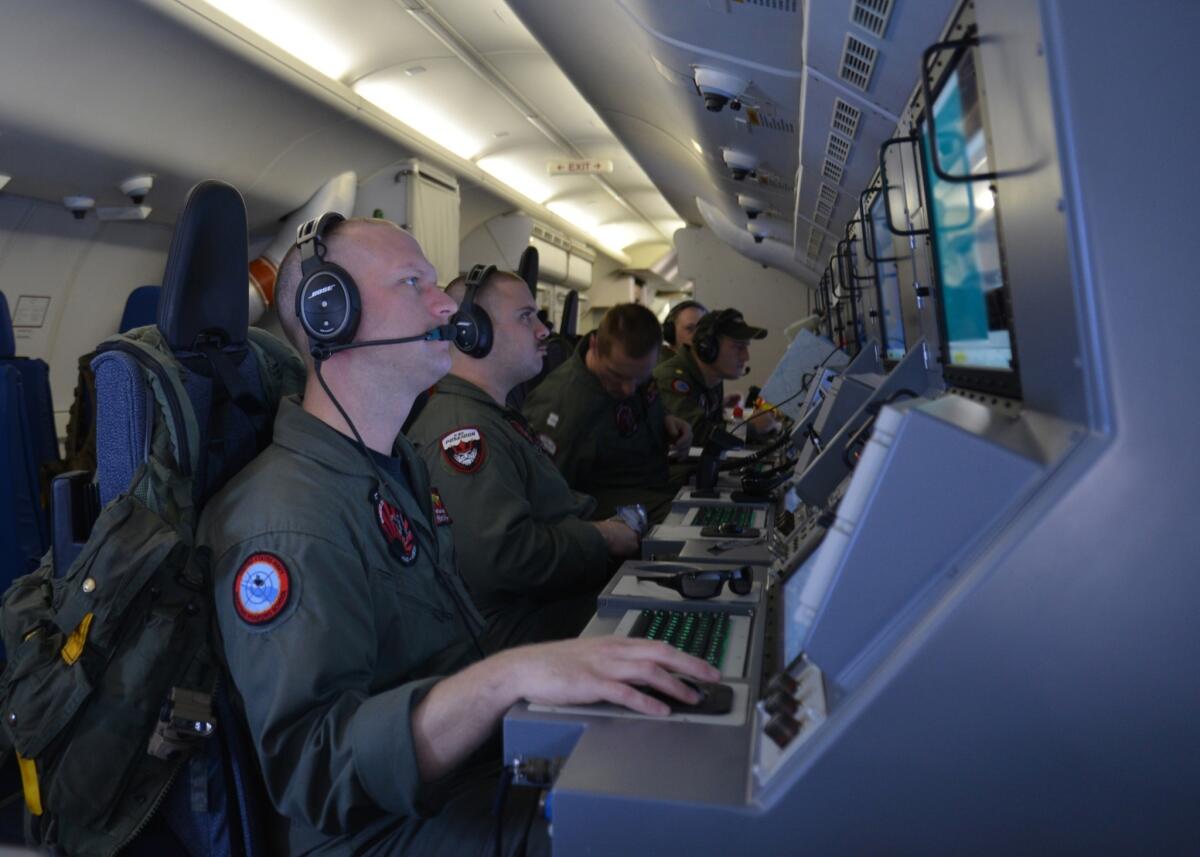 A handout provided by the U.S. Navy shows crew members on board a P-8A Poseidon assigned to Patrol Squadron VP-16 at their workstations while assisting in the search for Malaysia Airlines Flight 370 on Sunday over the Indian Ocean.