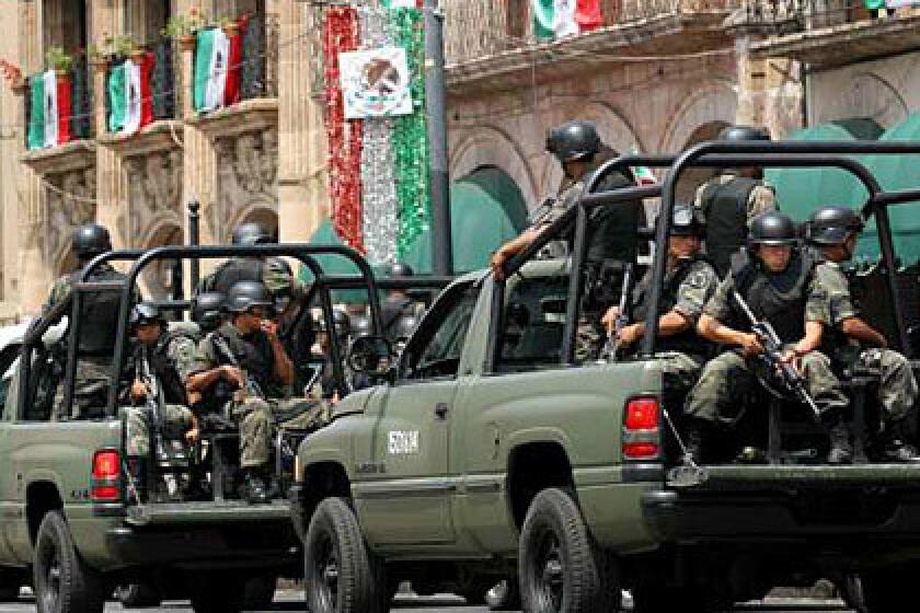 Soldiers ride on pickup trucks as they patrol the streets of Morelia on September 17 after deadly attacks on independence day celebrations sparked fears that civilians are now targets in the country's drug wars.