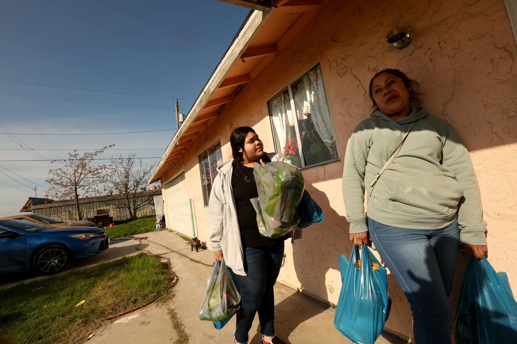 Alicia Zavala, right, and her daughter, Meyli Magana, return home after buying groceries in Goshen.