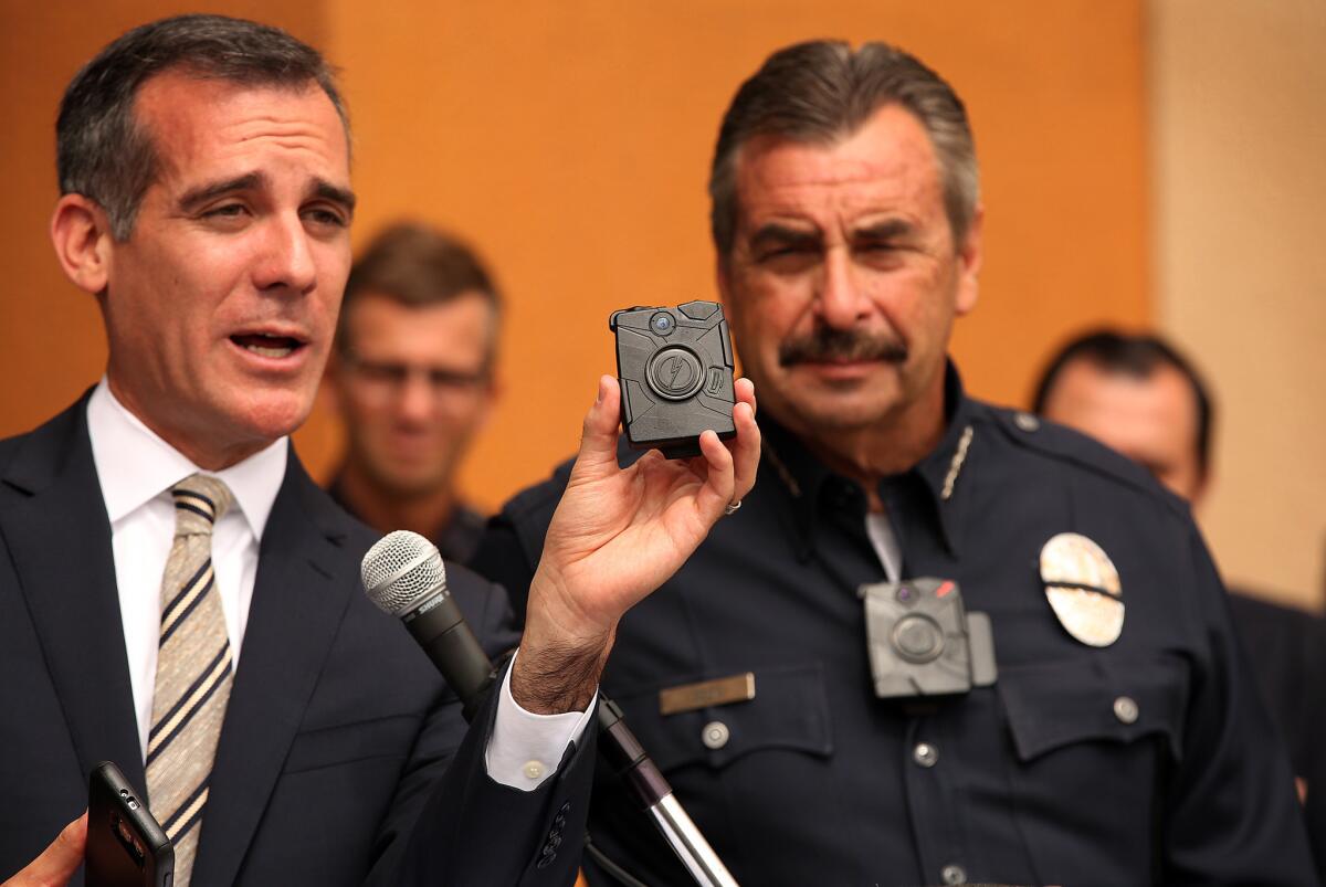 Los Angeles Mayor Eric Garcetti, left, displays a police body camera last year with LAPD Chief Charlie Beck, who is wearing one of the cameras.