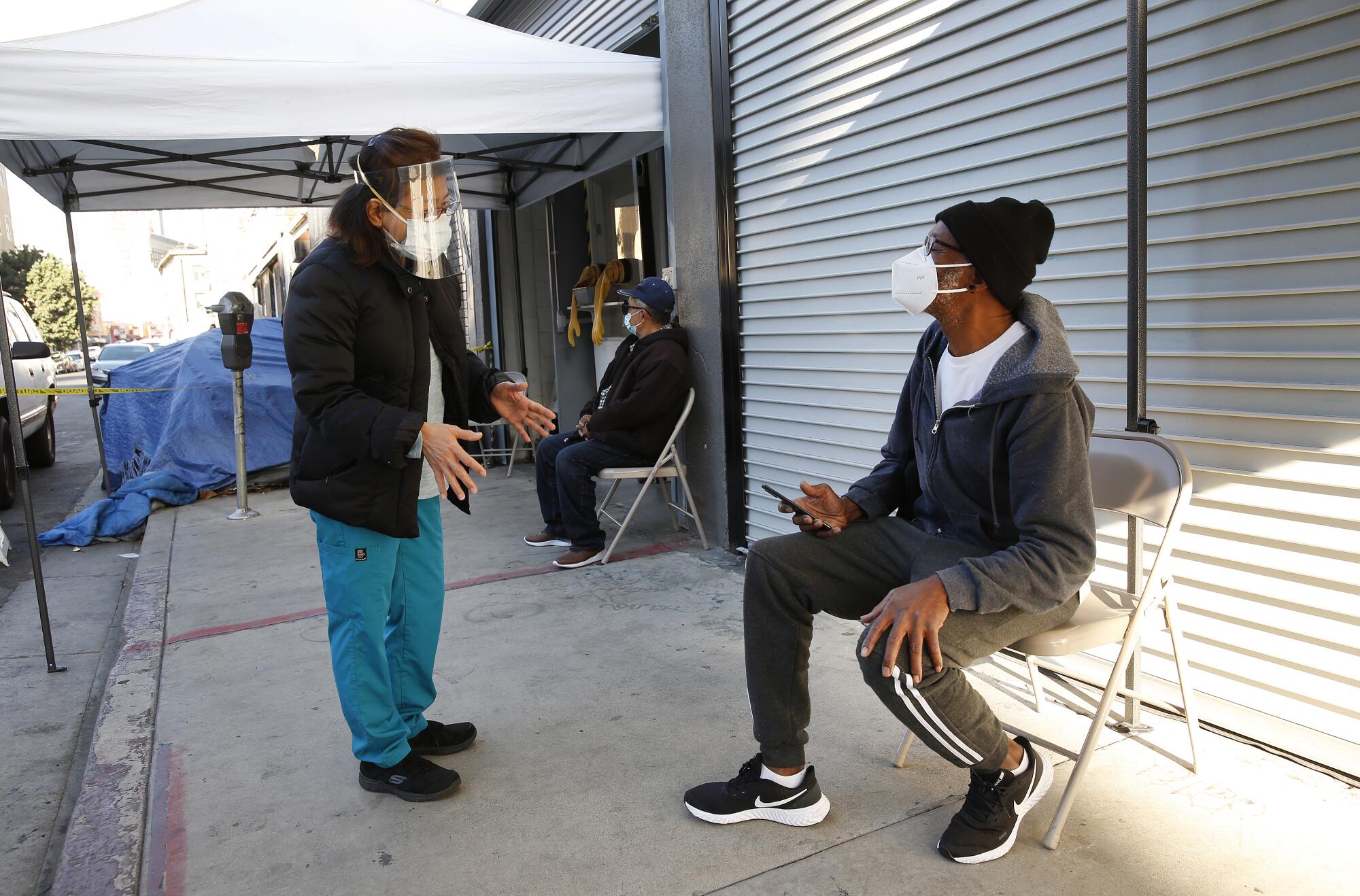 Huonglan Tran observes Vernal Primus, 69, for side effects after his COVID-19 vaccination.