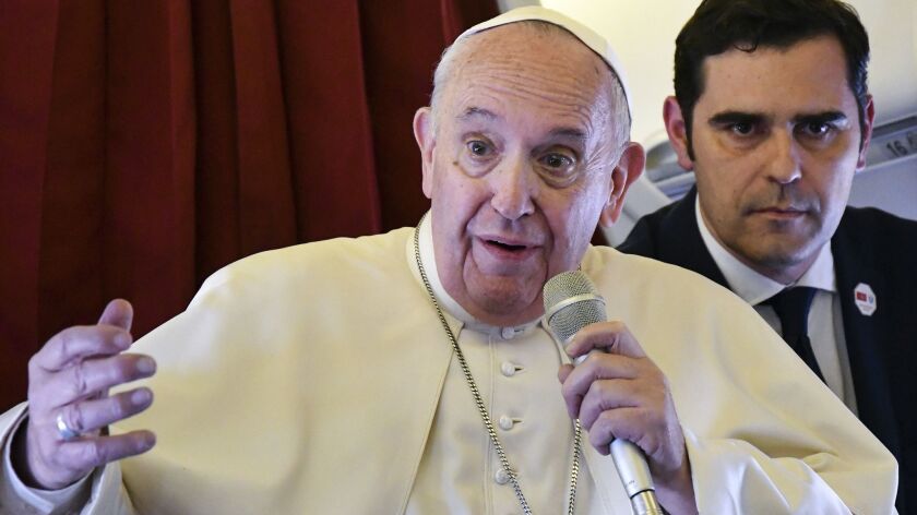 Pope Francis, accompanied by interim director of the Holy See Press Office, Alessandro Gisotti, speaks to reporters on board the flight back to Rome from a two-day trip to Morocco, on March 31, 2019.