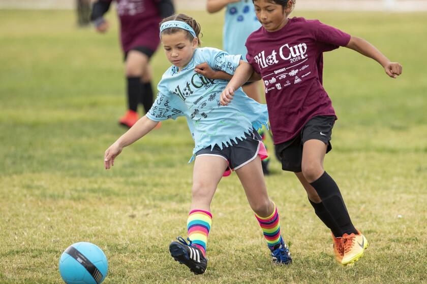 Costa Mesa Sonora's Vanessa Zarate battle for a ball against Costa Mesa St. Joachim Catholic School's Ceci Ball in a girls? third- and fourth-grade Bronze Division quarterfinal match at the Daily Pilot Cup on Saturday, June 1.