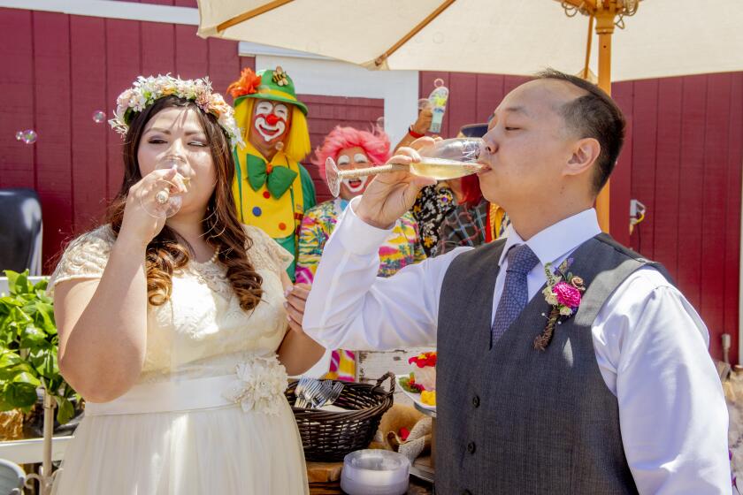 The wedding concluded, Leslie Leong and Michael Nguyen drink ceremonial glasses of champagne as clowns Tadpole and Katy watch. (Photo by Spencer Grant)