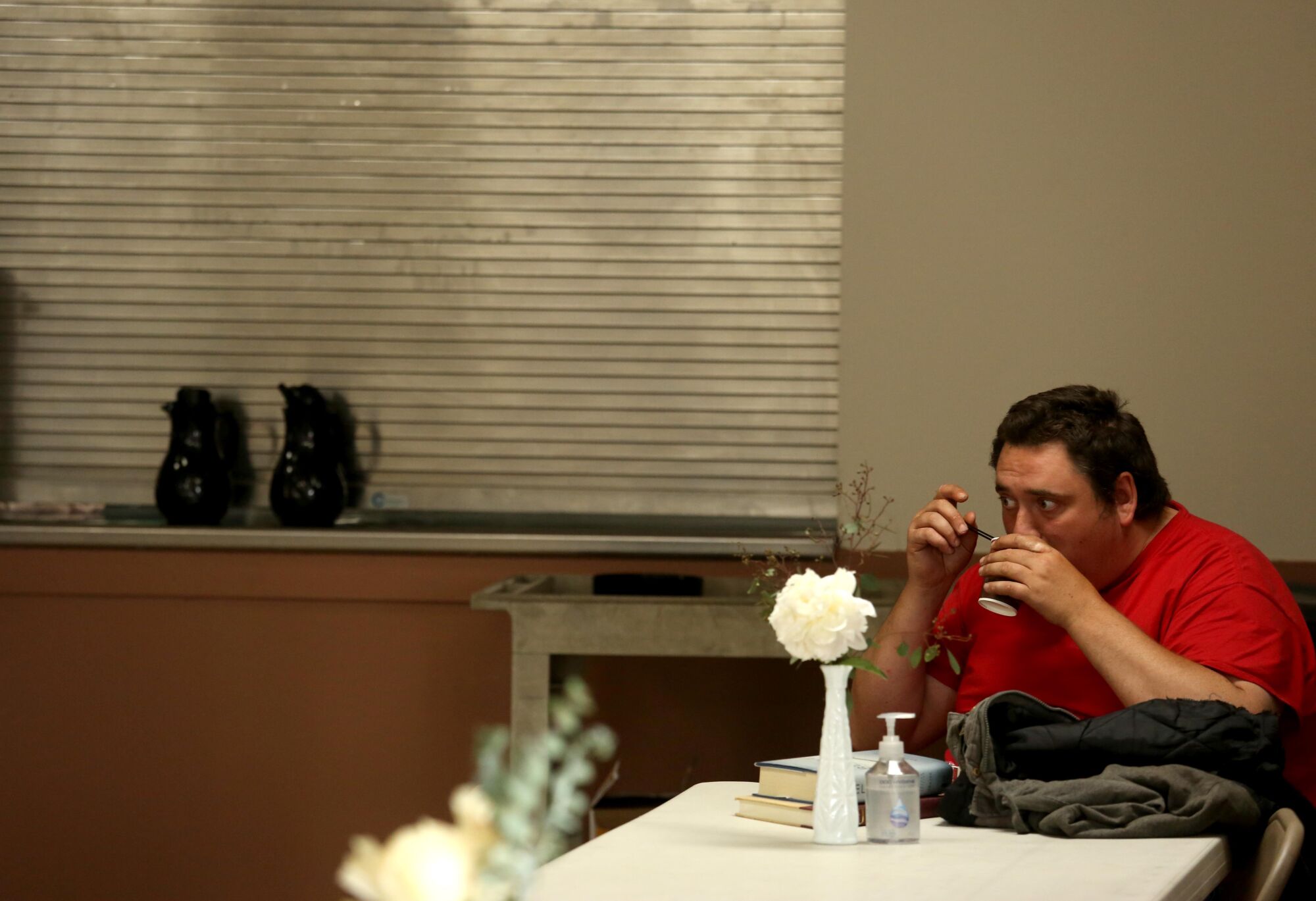 Andrew Truelove has a cup of coffee in the dining room at the Beacon Light Mission in Wilmington.