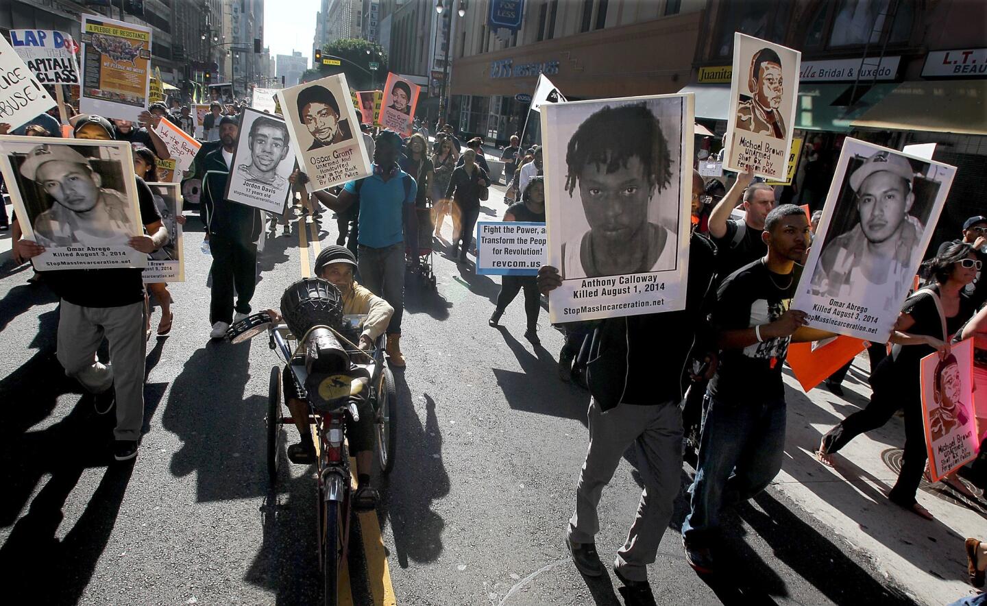 Marchers in downtown L.A. taking part in the National Day of Protest to Stop Police Brutality carry images of people who have died at the hands of police.