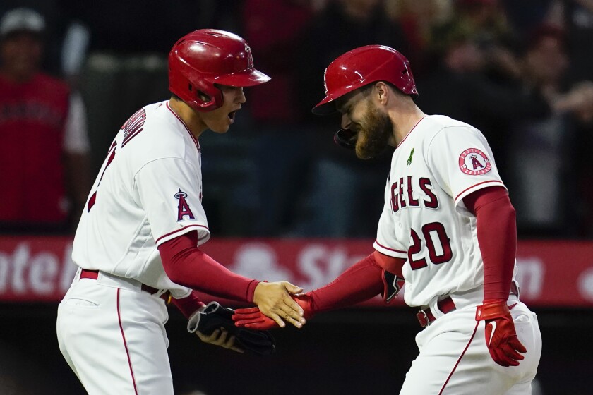 Jared Walsh of the Angels celebrates with Shohei Ohtani after hitting a home run in the third inning.