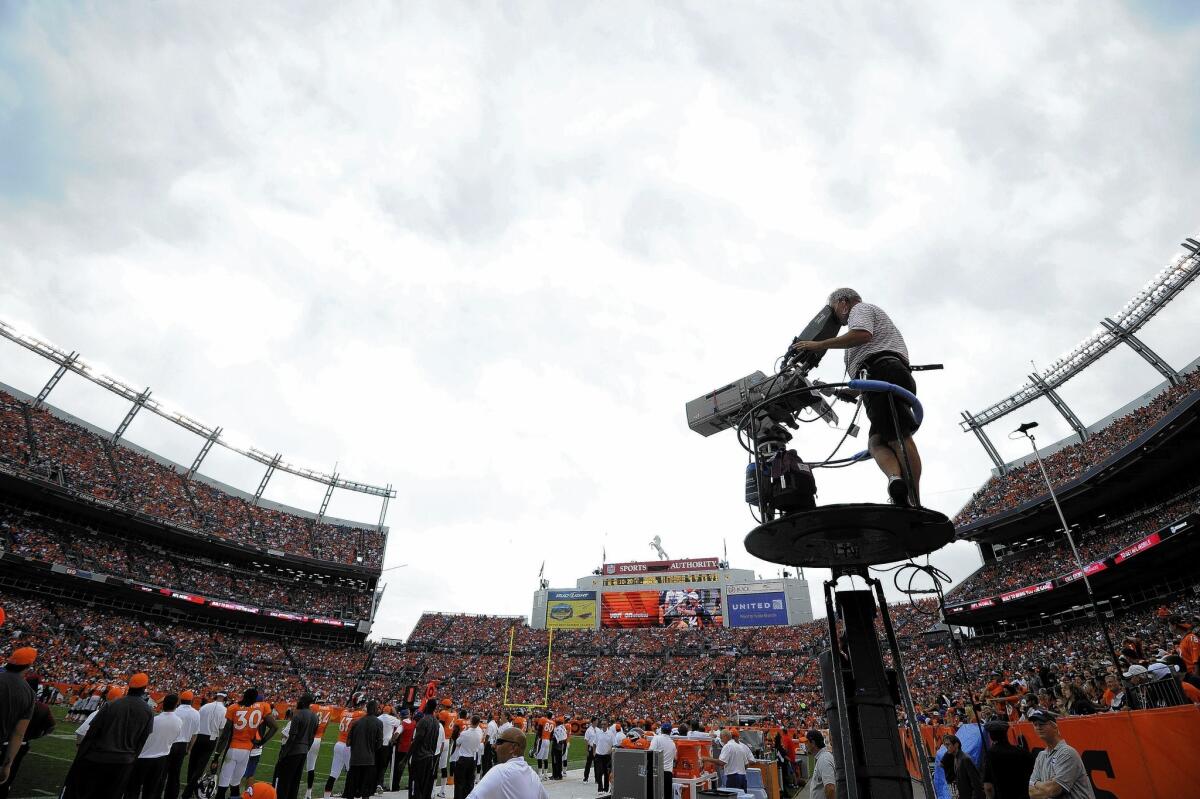 DirecTV pays $1 billion a season for the rights to all Sunday afternoon NFL games under an exclusive deal that runs through next season. Above, a CBS Sports cameraman during a game between the Houston Texans and Denver Broncos in September 2012.