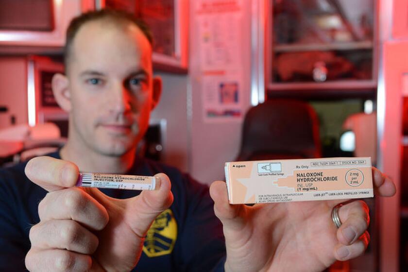 Eau Claire, Wis., Fire Department EMT and paramedic Matt Gunderson holds a dose of naloxone.