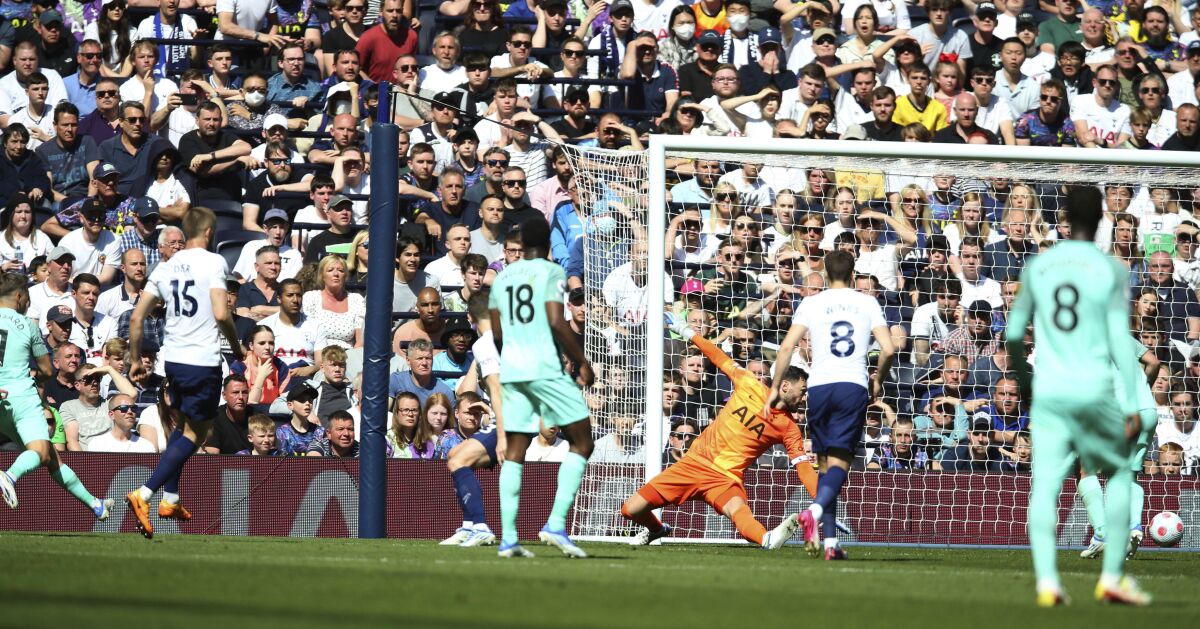 Brighton and Hove Albion's Leandro Trossard, left, scores his side's first goal during the English Premier League soccer match against Tottenham Hotspur, at the Tottenham Hotspur Stadium, London, Saturday, April 16, 2022. (Nigel French/PA via AP)