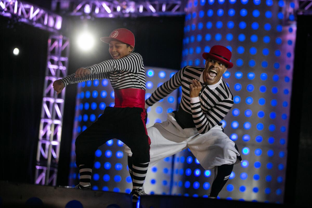 Flomaster and his son Prince onstage in black-and-white striped outfits