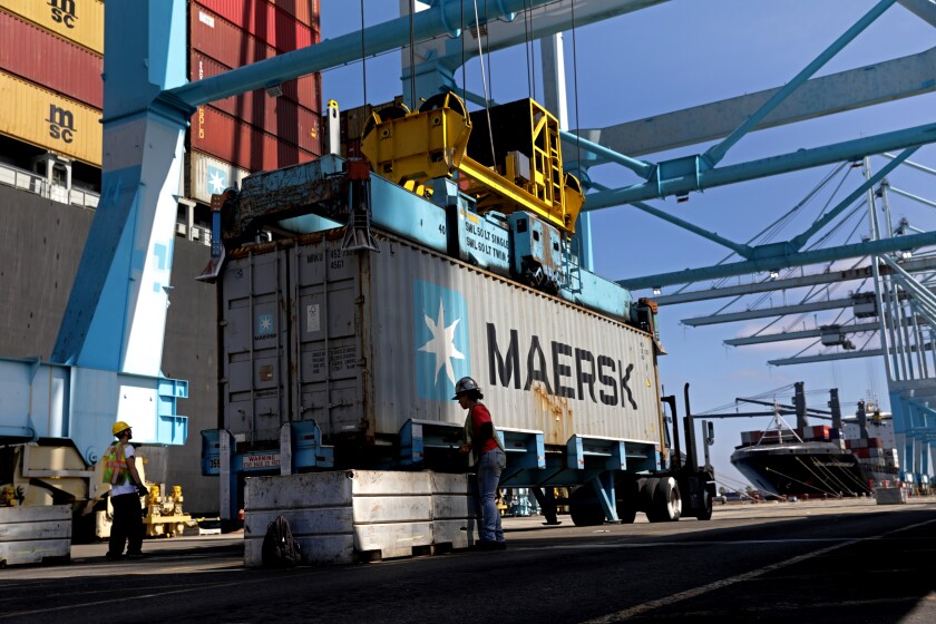 A crane puts containers on a vessel at the Port of Los Angeles