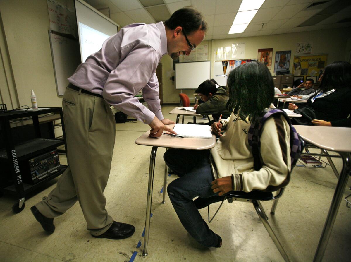 Kyle Hunsberger explains a problem to Robert Gunter as he teaches his pre-algebra Math 7 class at Johnny Cochran Middle school in Los Angeles. He participated in L.A. Unified's controversial teacher evaluation program, which uses student standardized test scores as one measure of how well teachers help students learn. A state appellate court ruled Thursday that teacher names need not be publicly disclosed along with their performance ratings.