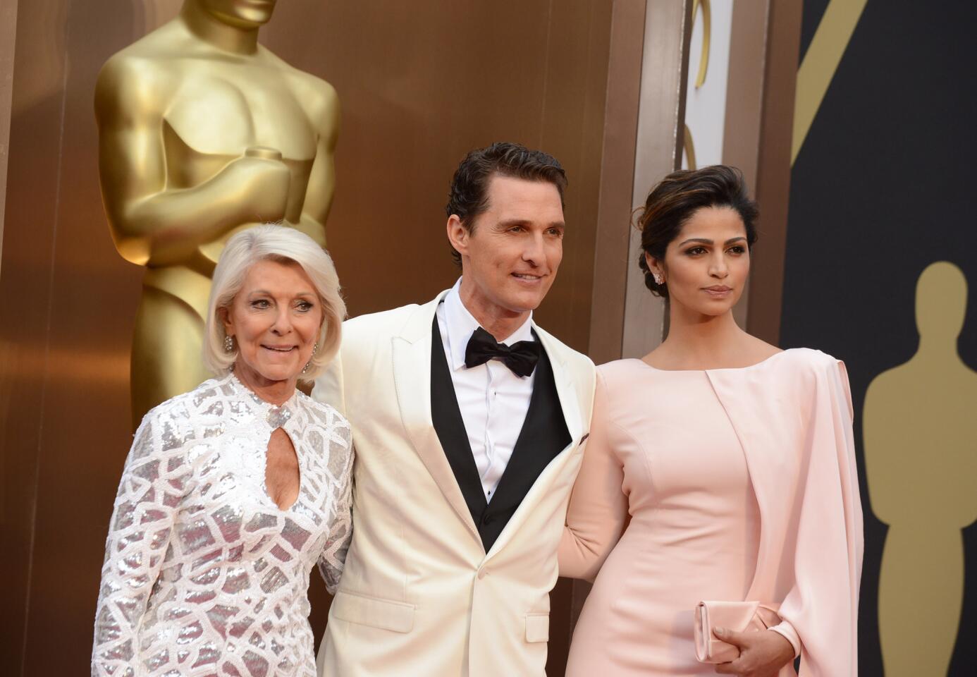 Matthew McConaughey is flanked by his mother Mary Kathlene McCabe, left, and wife Camila Alves, right, on the red carpet at the 86th Annual Academy Awards on March 2, 2014.
