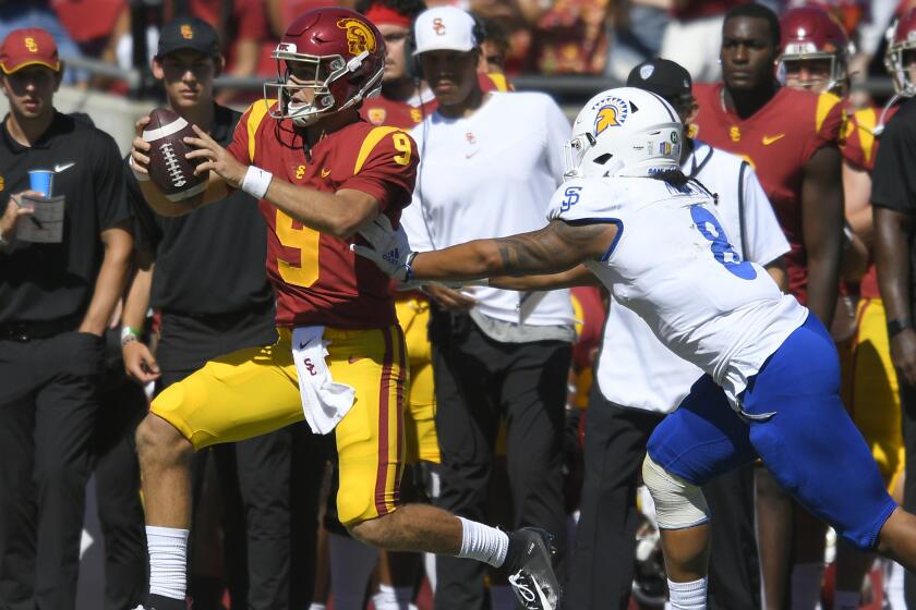 San Jose State Spartans linebacker Alii Matau pushes USC Trojans quarterback Kedon Slovis.
