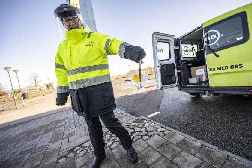 A member of staff collects the last COVID-19 PCR tests, at the Covid testing site of Svagertorp, Malmoe, Sweden, Tuesday, Feb. 8, 2022. Starting Wednesday, Sweden ends the wide-scale testing for COVID-19 even among people showing symptoms of coronavirus infection, a move that puts the Scandinavian nation at odds with most of Europe but could become the norm as the costs of testing yields fewer benefits as the omicron variant proves milder and governments begin to consider treating covid-19 as other endemic illnesses. (Johan Nilsson/TT via AP)