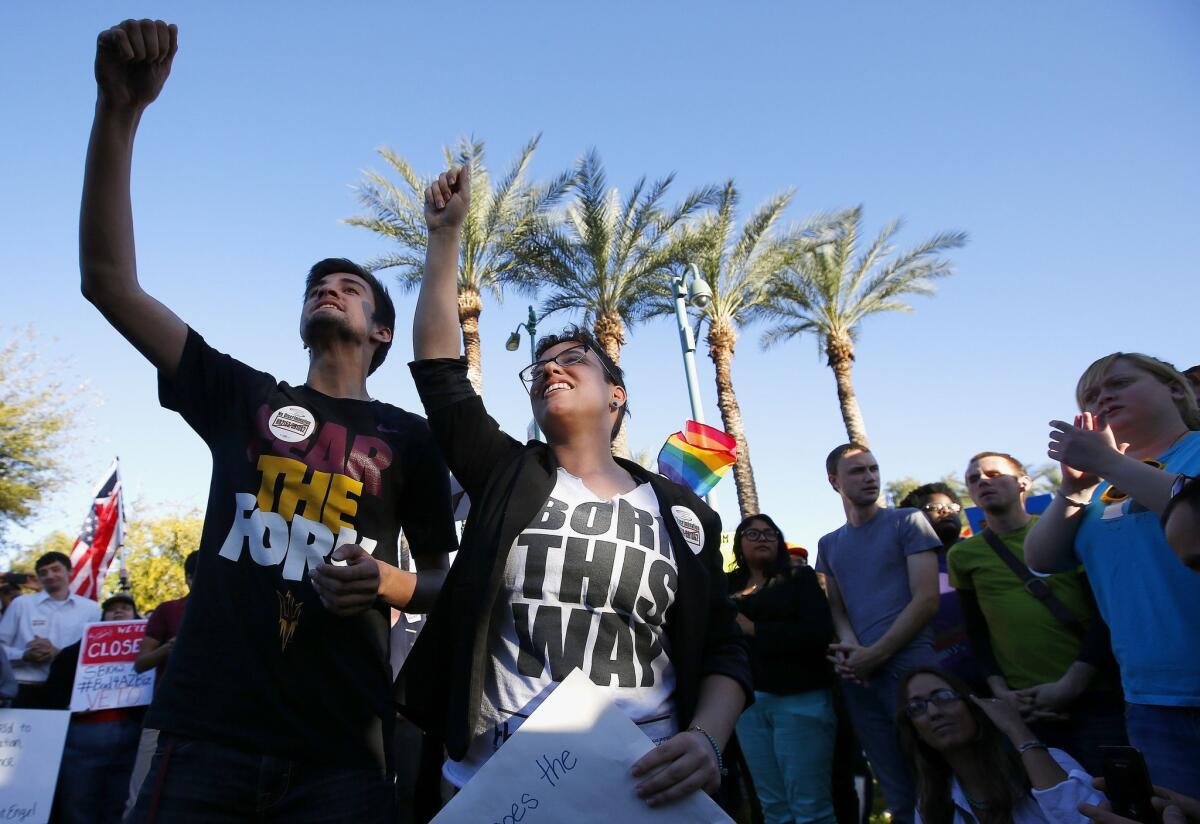 Anthony Musa, left, and Brianna Pantillione join nearly 250 gay rights supporters protesting SB 1062 at the Arizona Capitol.