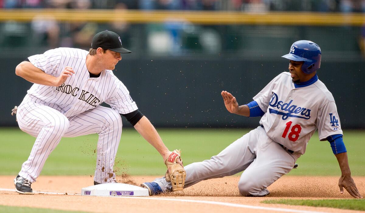 Dodgers second baseman Chone Figgins steals third base ahead of the tag by Colorado's D.J. LeMahieu during a game last week in Denver.