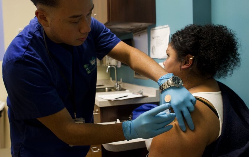 A patient receives a flu vaccination in Los Angeles. Health officials confirmed the first flu death of the season this week.