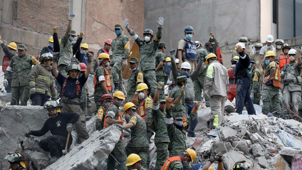 Rescue workers ask for silence to listen for signs of survivors underneath the rubble of a six-story residential building in Mexico City.