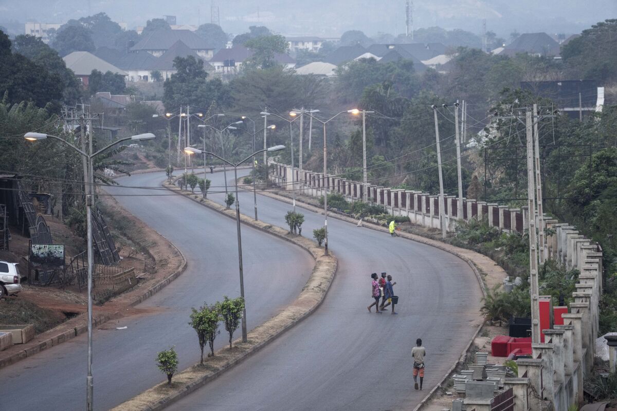 People walk across a normally packed highway during a separatists imposed lockdown in Enugu, Nigeria, Monday Feb. 14, 2022. Large parts of southeastern Nigeria come to a halt each Monday, as a separatist group has ordered all residents to stay at home to show support for their campaign for the region to become an independent country. For more than eight months the Indigenous People of Biafra organisation has directed people to carry out the strikes as they press for the region to break away from Nigeria. (AP Photo/Jerome Delay)