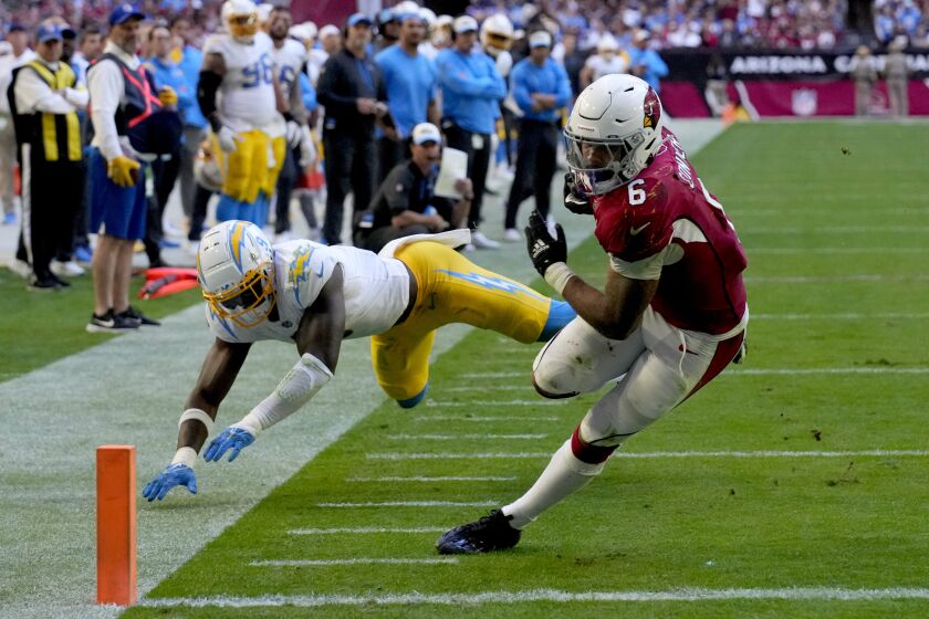 Arizona Cardinals running back James Conner (6) scores a touchdown as Los Angeles Chargers linebacker Kenneth Murray Jr. (9) defends during the second half of an NFL football game, Sunday, Nov. 27, 2022, in Glendale, Ariz. (AP Photo/Rick Scuteri)