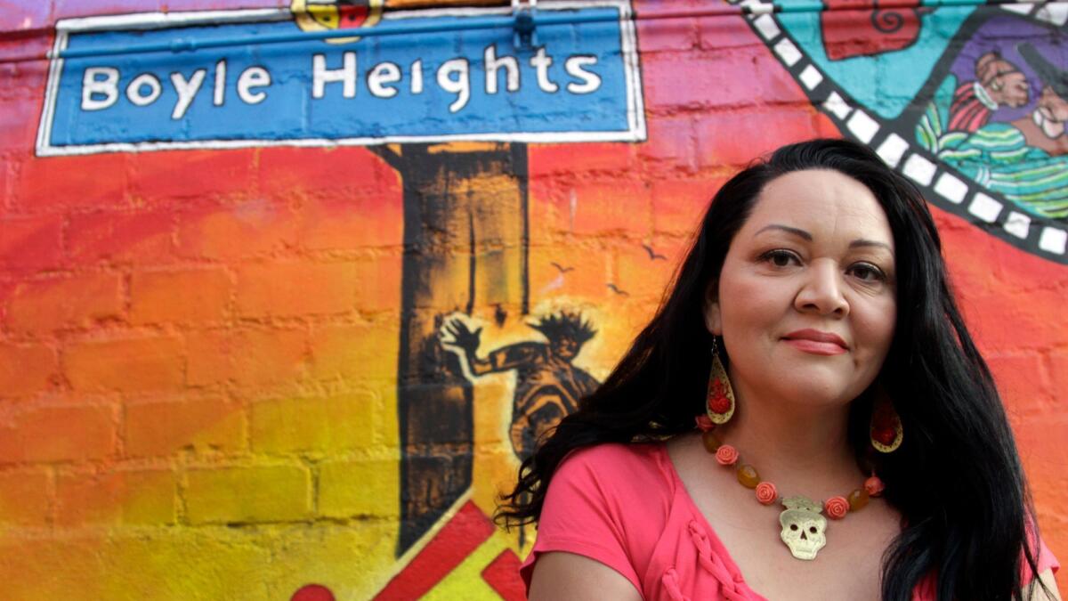 Writer Josefina Lopez sits before a mural at Casa 0101 Theater in Boyle Heights, which she established in 2000.