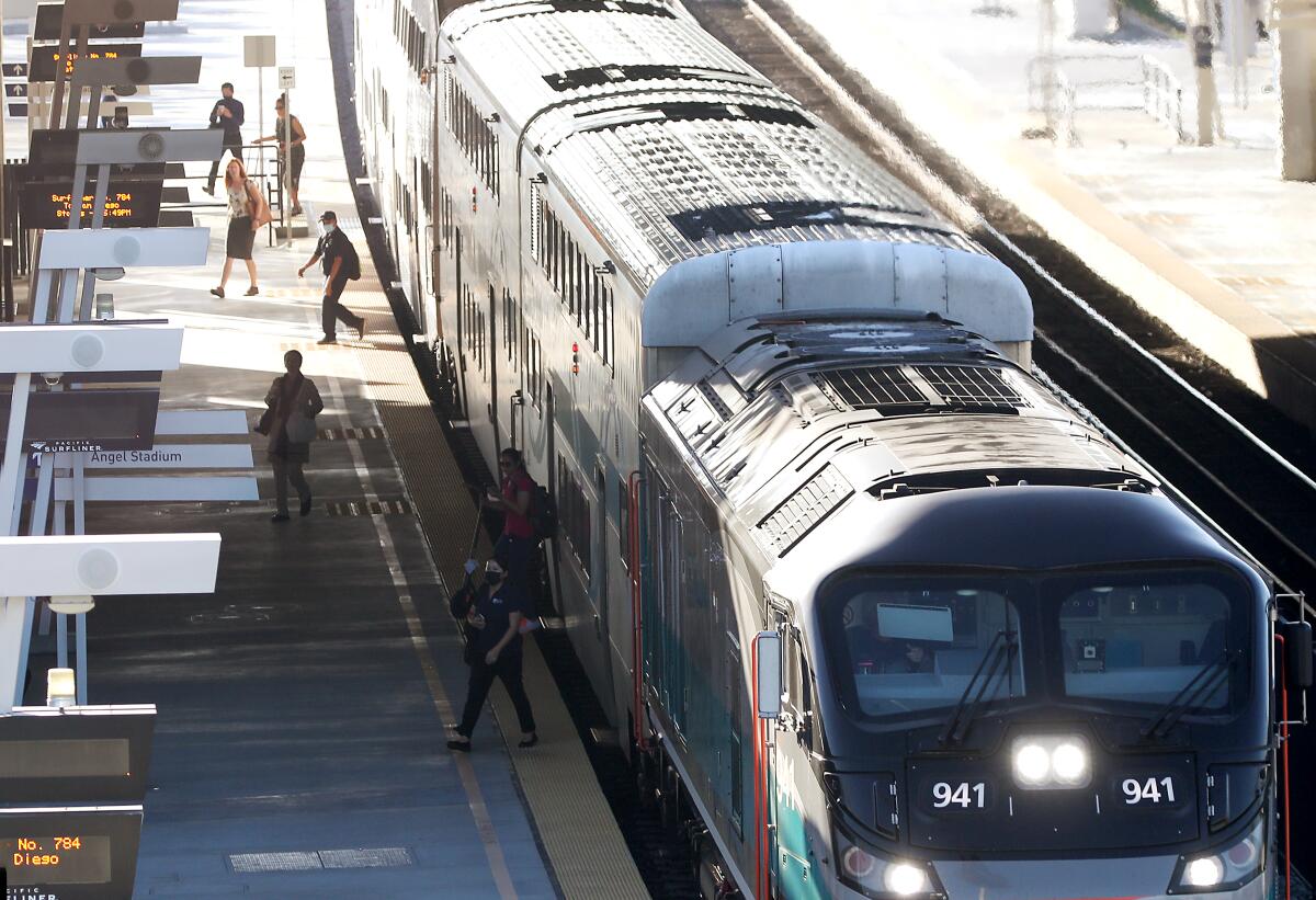 Passengers get off a Metrolink train in Anaheim.
