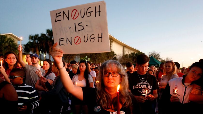 Mourners attend a candlelight vigil for the victims of the Marjory Stoneman Douglas High School shooting in Parkland, Fla.