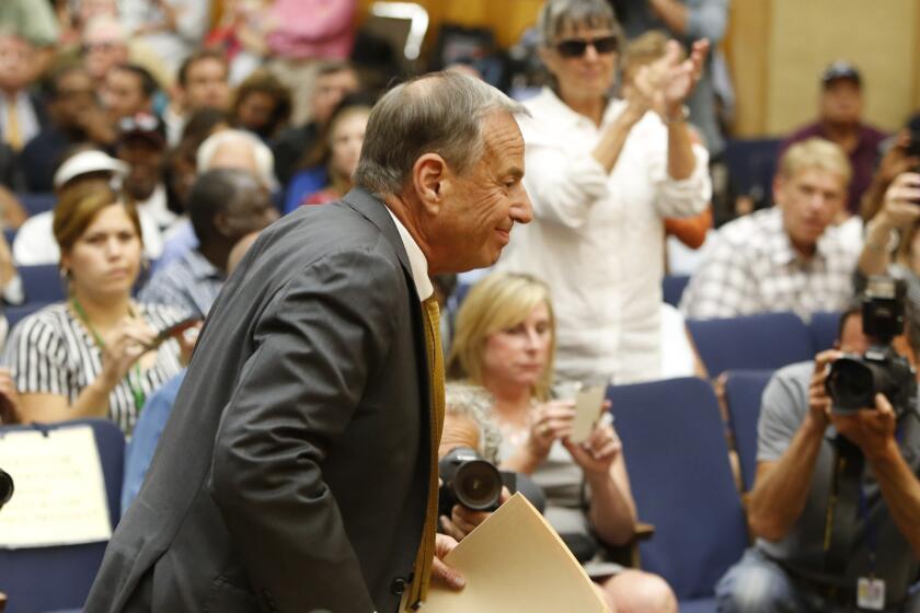 Bob Filner enters the San Diego council chambers to announce that he is resigning as mayor as his supporters applaud in the background. He was publicly accused of sexual harassment by many women.