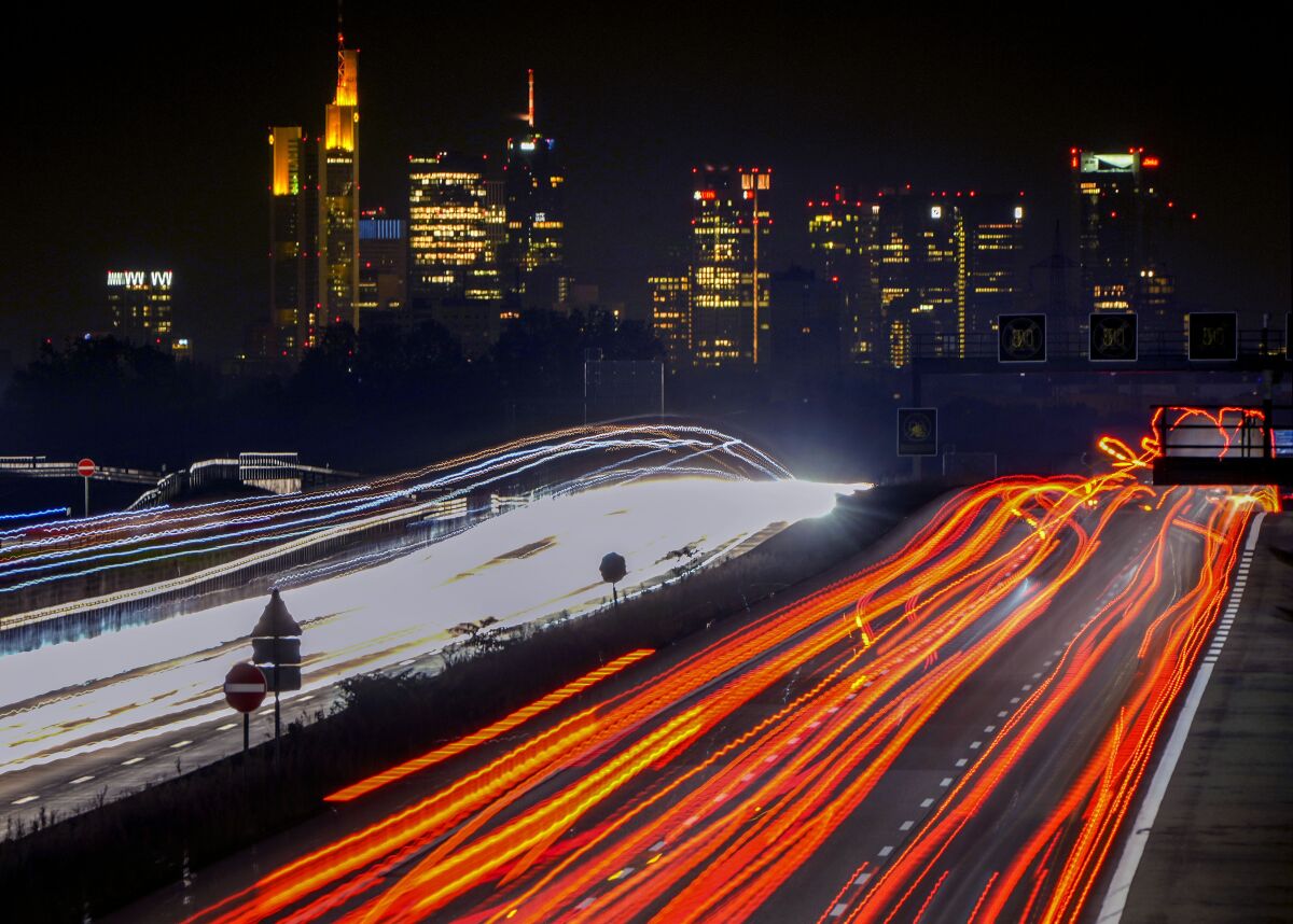 FILE - Cars and trucks move on a highway toward Frankfurt, early Nov. 5, 2021. Several countries and companies plan to accelerate the switch to emissions-free ground, air and sea transport at part of efforts to curb global warming. (AP Photo/Michael Probst, File)