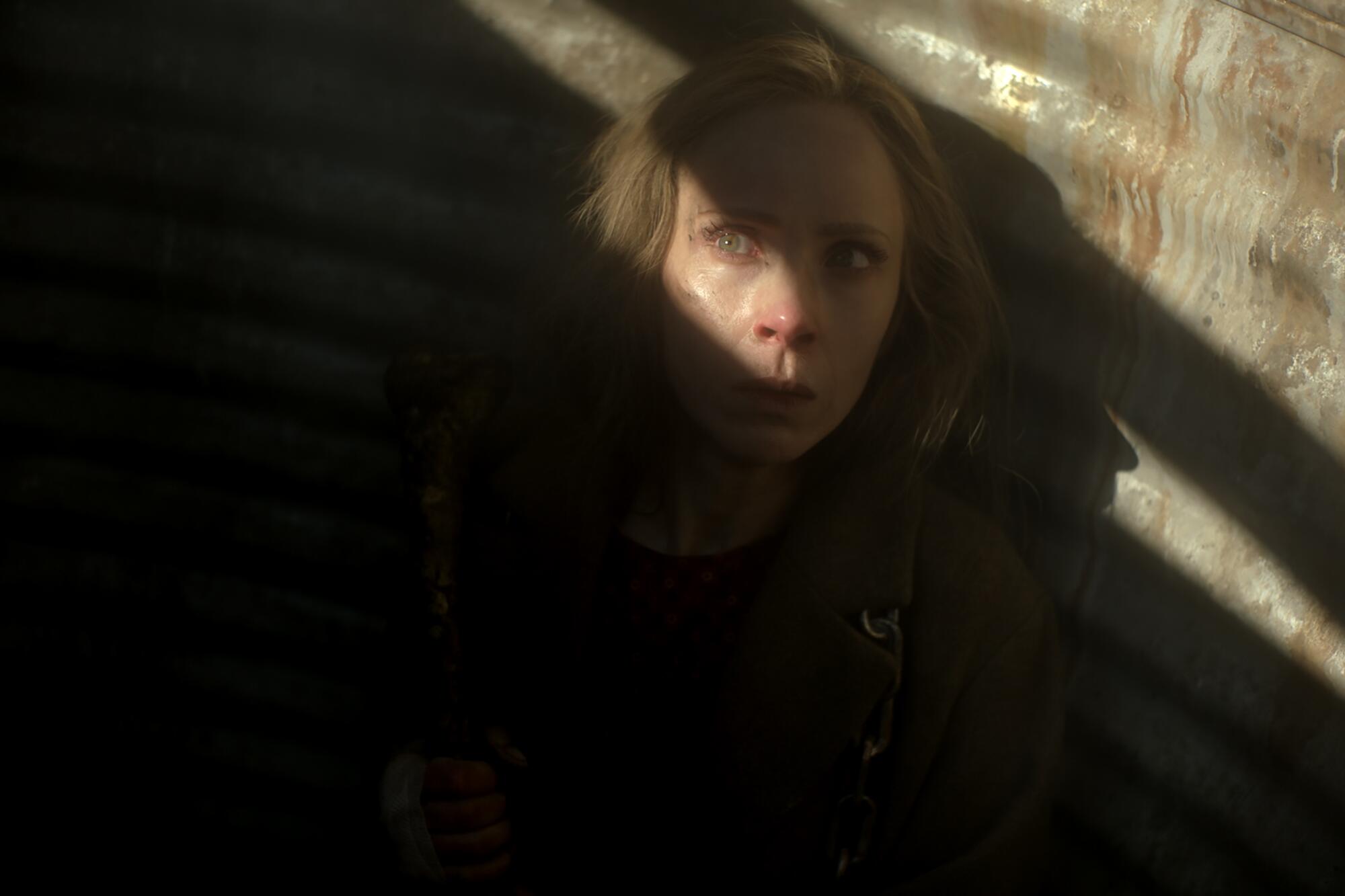 A woman cowers in the shadows with streaks of light crossing her face in "Fargo."