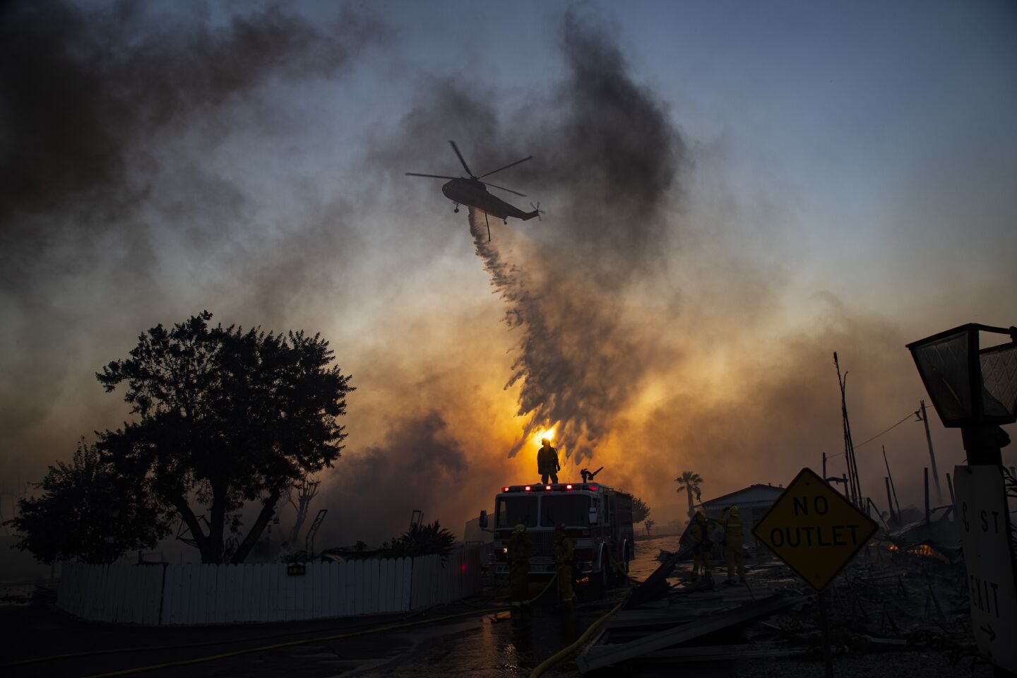 CALIMESA, CA - OCTOBER 10, 2019: A water dropping helicopter drops water on burning mobile homes to try and keep the Sandalwood fire from spreading at Villa Calimesa mobile home park on October 10, 2019 in Calimesa, California. Multiple mobile homes were lost in the fire.(Gina Ferazzi/Los AngelesTimes)