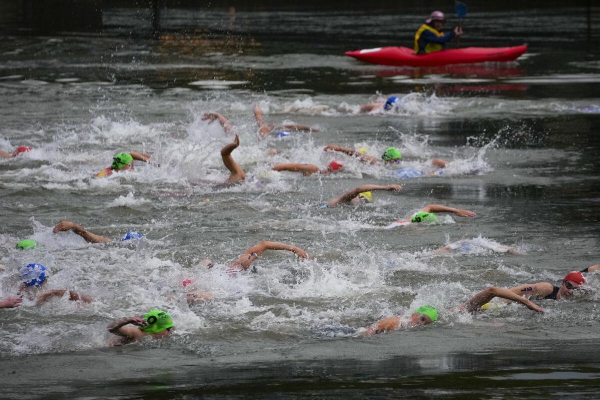 Athletes compete during the swimming portion of the women's triathlon in the Seine River on Wednesday.