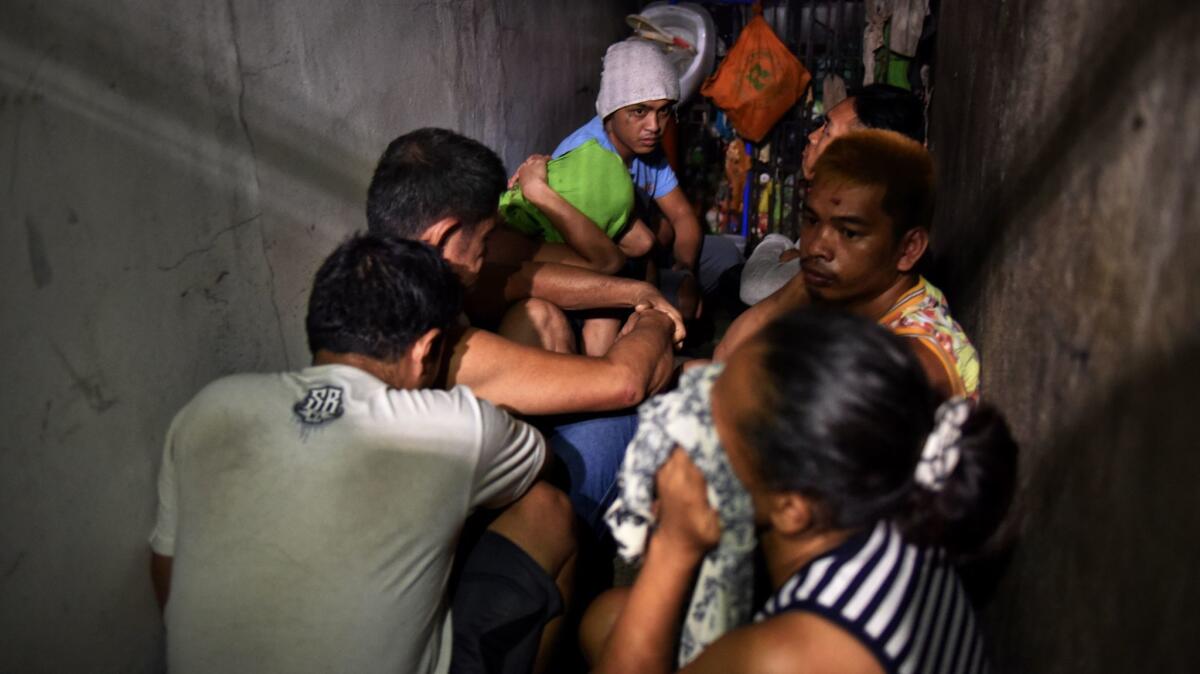 Drug suspects are detained at a secret cell behind a wooden cabinet in Manila.