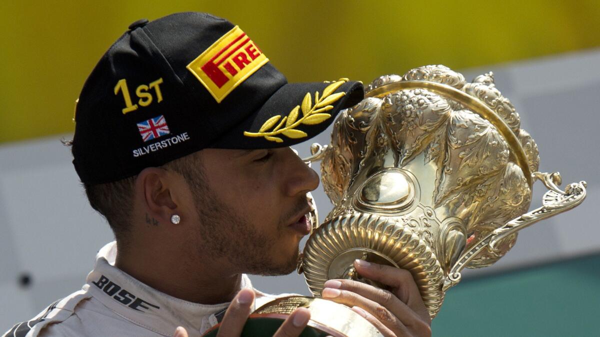 Lewis Hamilton kisses his trophy on the podium after winning the Formula One British Grand Prix at the Silverstone on Sunday.